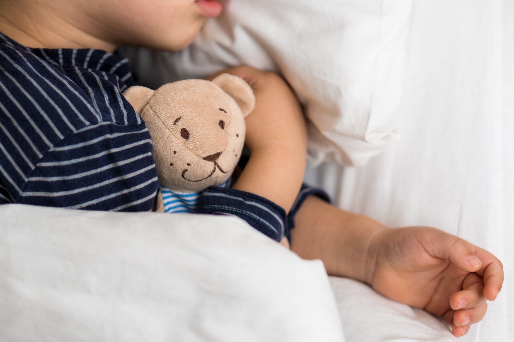 Child Hugging Teddy Bear While Sleeping